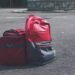 Red and Gray Backpack Beside Red Duffel Bag