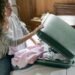 Focus woman packing suitcase on bed