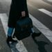 Person Carrying Bag Walking on Pedestrian Lane