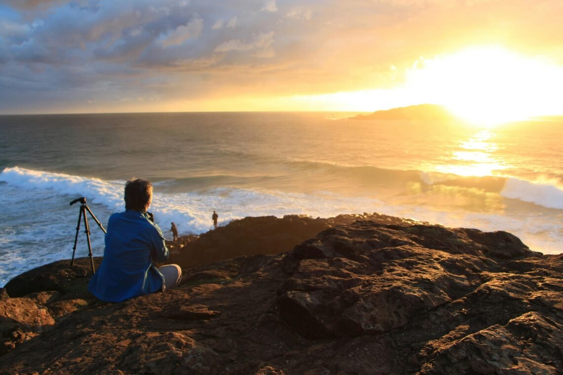 Person Sitting on Cliff Watching Sunset